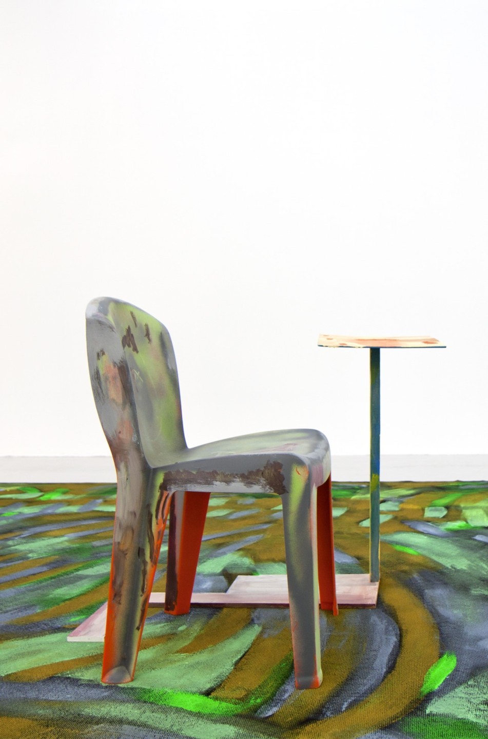 L'oeuvre est constituée d'une chaise en plastique peinte et d'une petite table en bois peinte également.