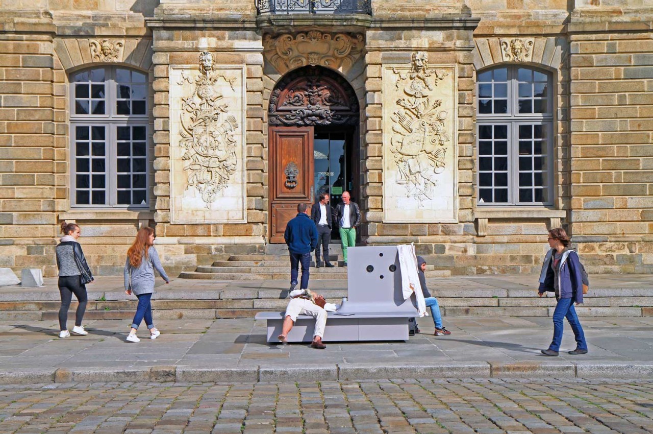 Photographie de la performance Invincible, montrant 8 personnes devant un monument.