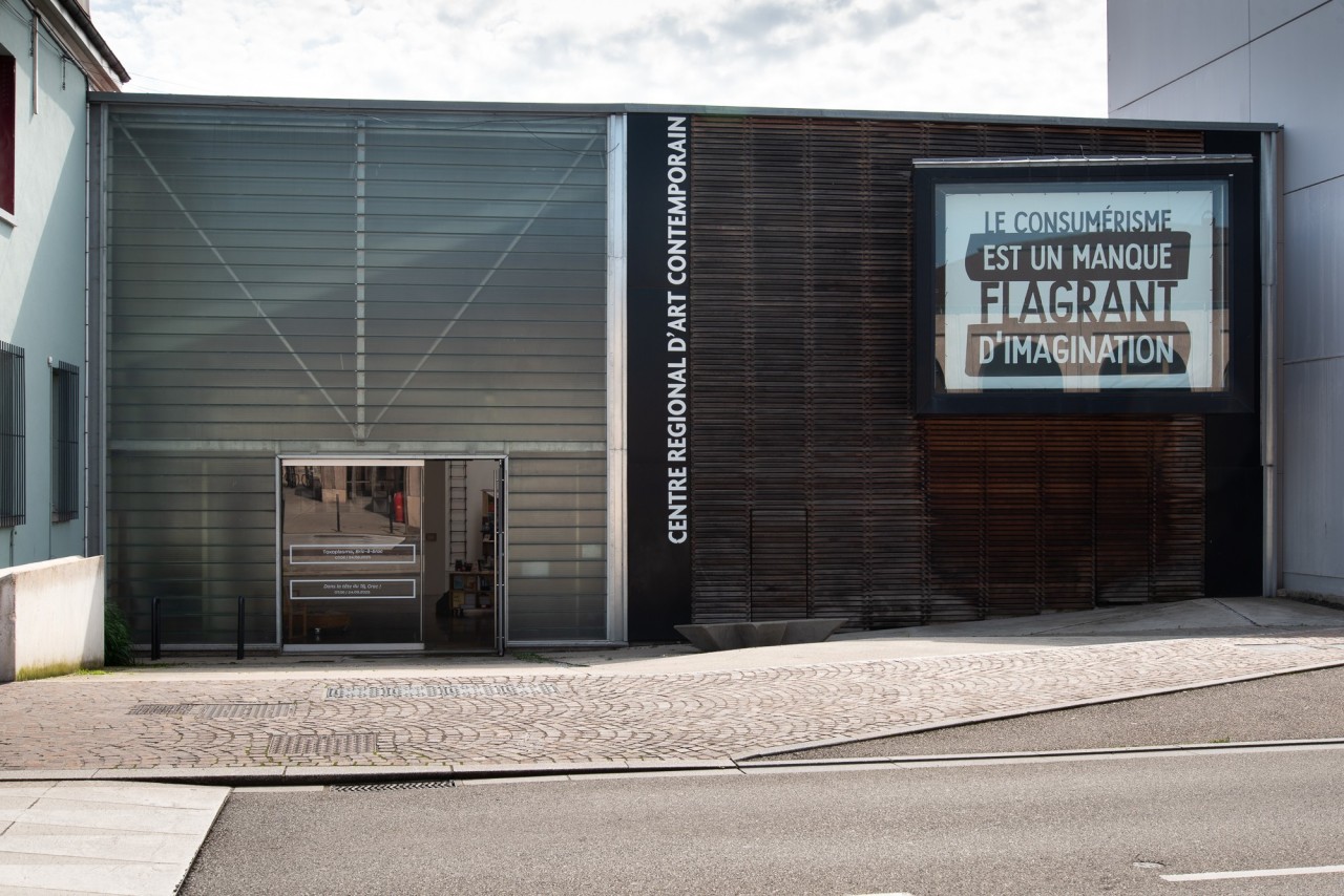 Slogan "le consumérisme est un manque flagrant d'imagination" dans une vitrine.