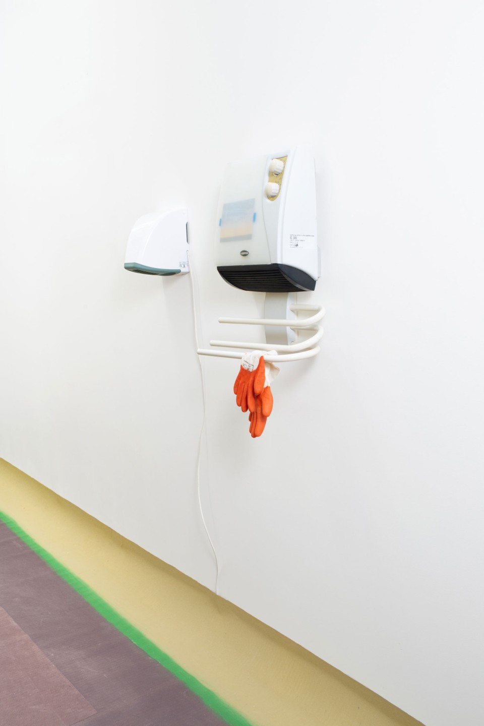 L'oeuvre est composé d'un séchoir sur mur, d'une barre en dessous sur laquelle est posée une paire de gants de travail.