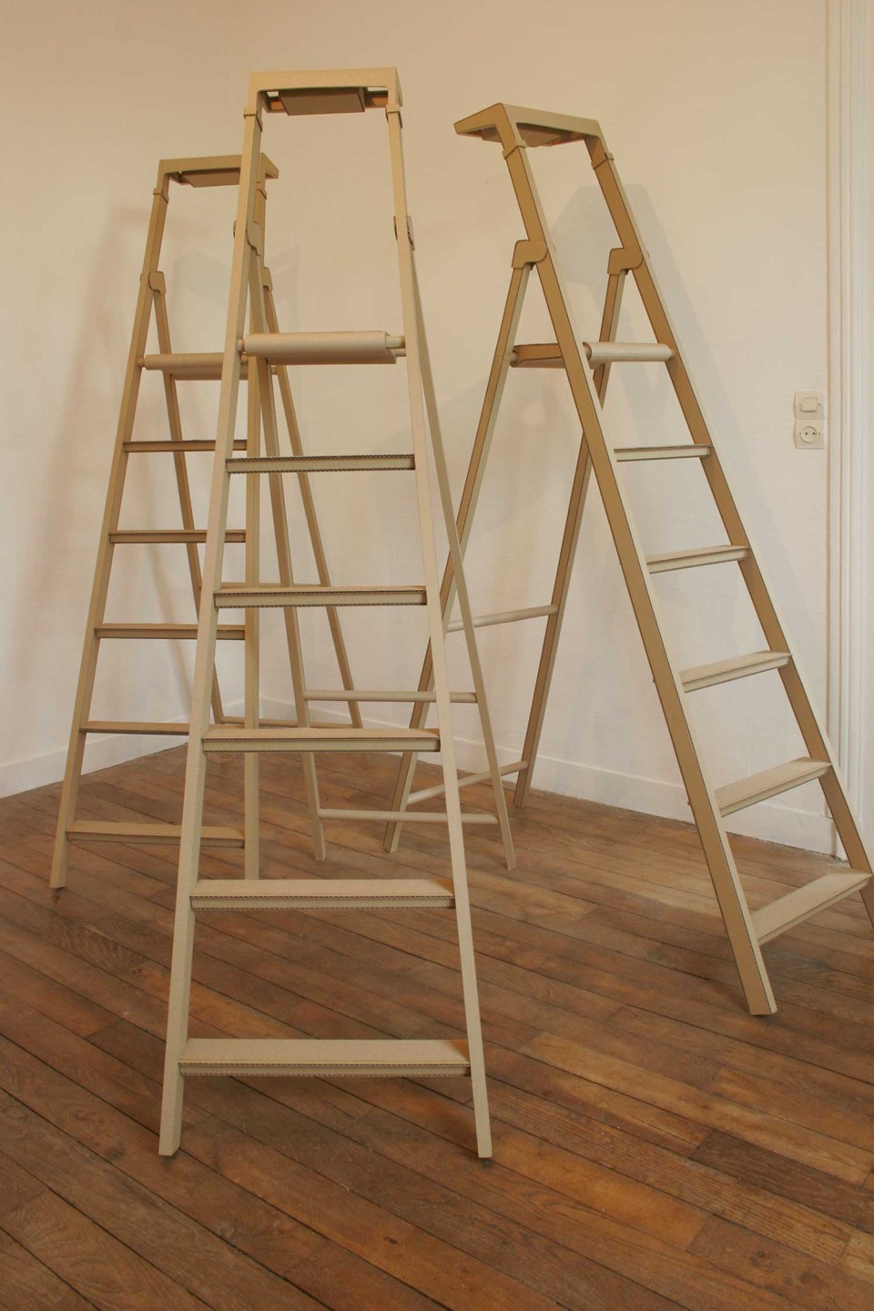 Trois escabeaux dans une pièce