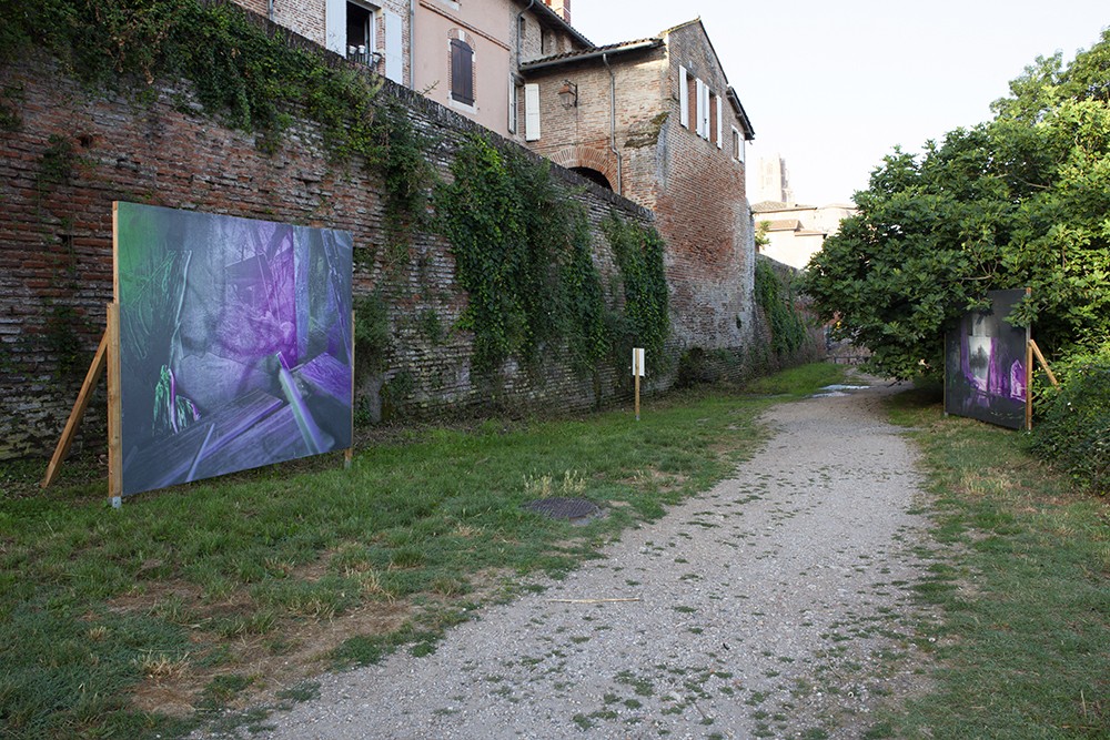 2 images monumentales de part et d'autre d'un chemin en contrebas de maisons anciennes