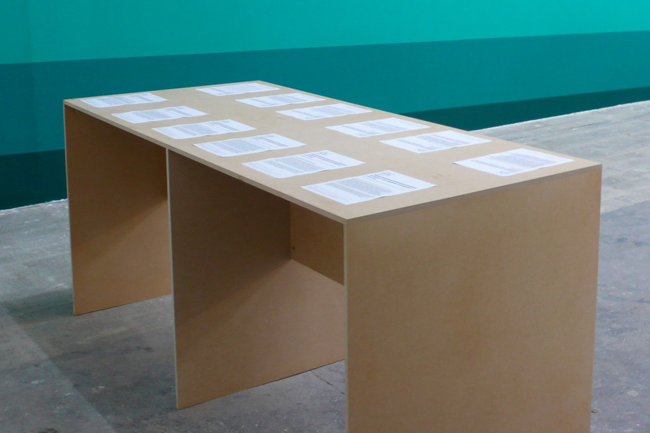 Vue d'une table en bois avec douze feuilles A4 posées