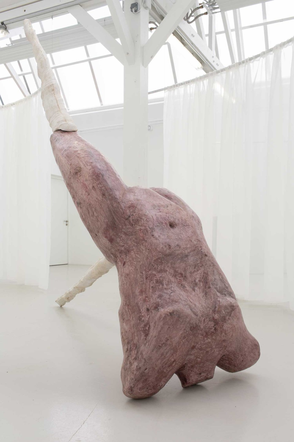 L'oeuvre est une scuplture imposante ayant la forme d'un buste humain rouge avec des jambes, reposant sur son coup. La moitié inférieur de ses jambes sont des pics blancs.