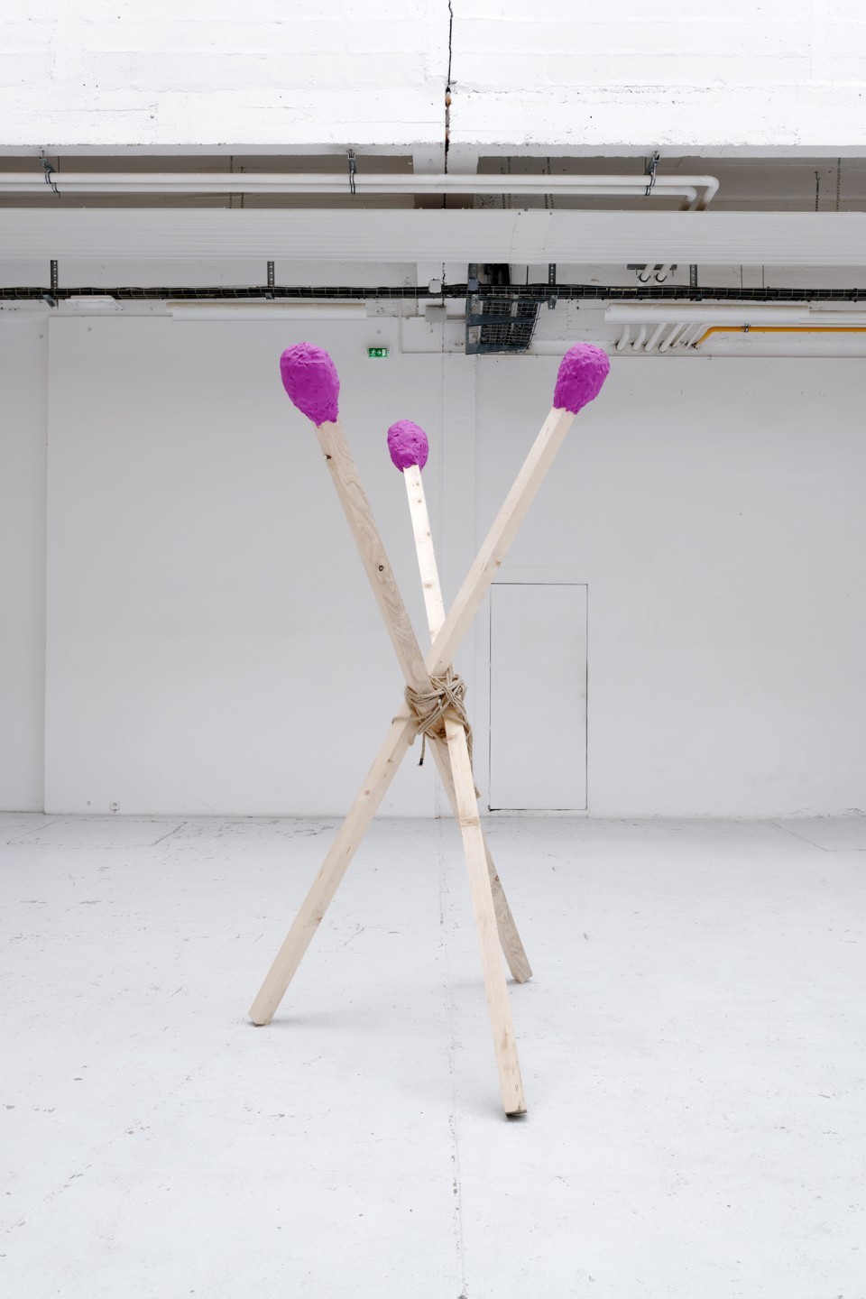 En pendant de ces toiles et oeuvres sur papier, l’artiste tente la production en volume avec des fagots d’allumettes démesurées aux têtes pourpres prêtes à embraser l’espace du centre d’art.