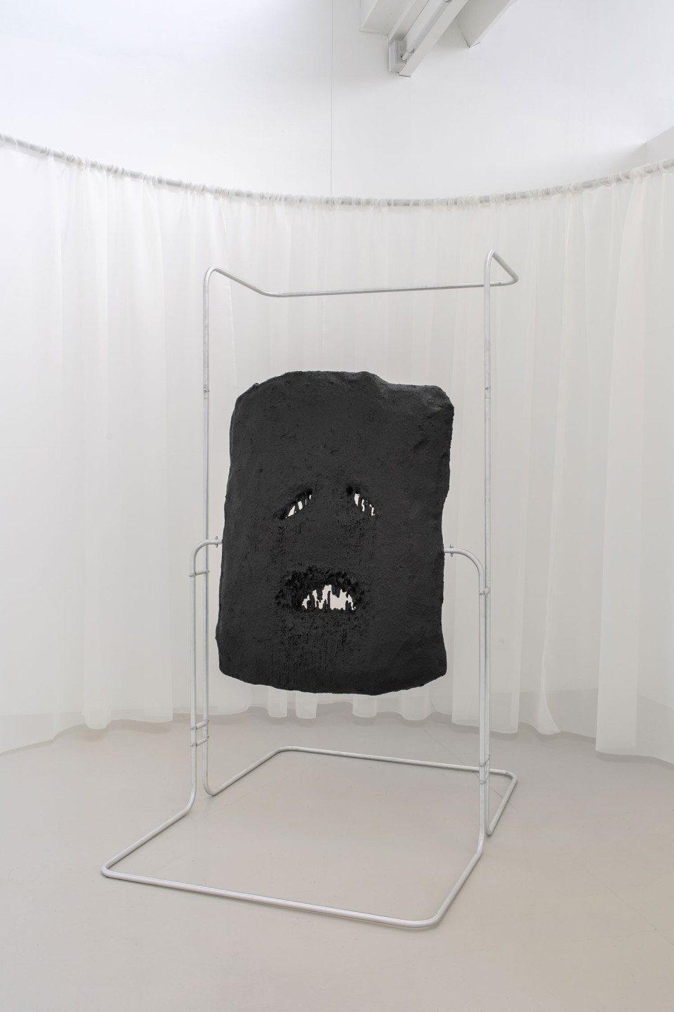 L'œuvre est une sculpture en cire teinte, jesmonite sur une structure aluminium, représentant un visage abstrait.