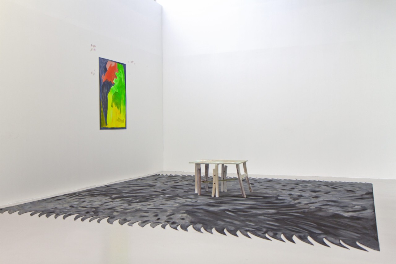 L'oeuvre est un tapis de 4 mètres par 4.la moquette noire et repeinte de sorte qu'on y vois des traces blanches et grises.