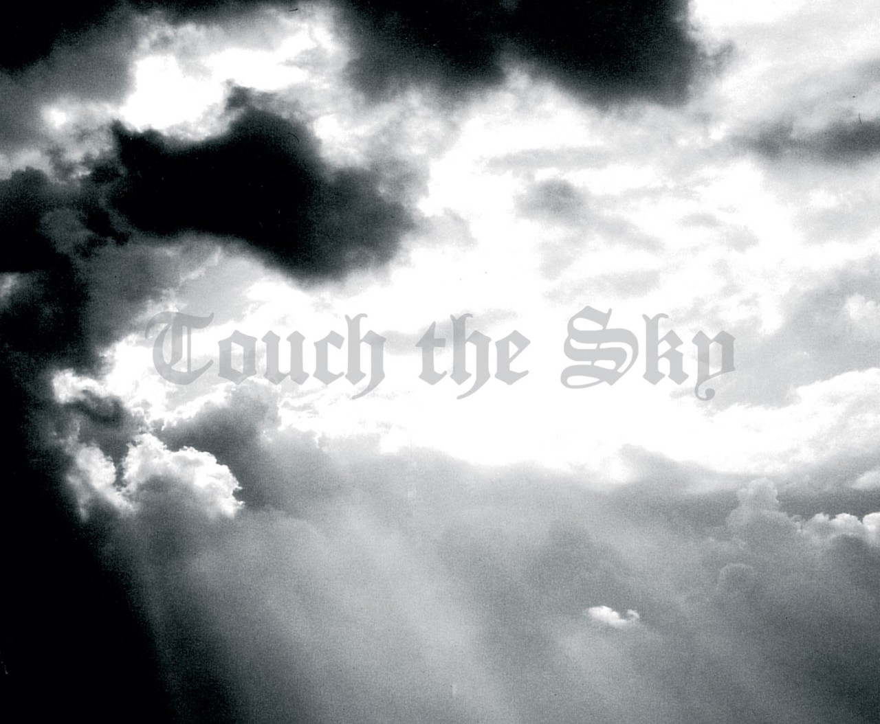 Photo de ciel avec typo gothique "Touch The Sky"